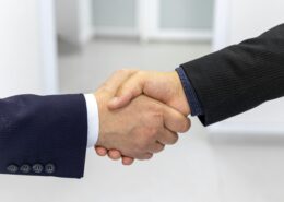 Business handshake representing trust and commitment in a signature coaching program