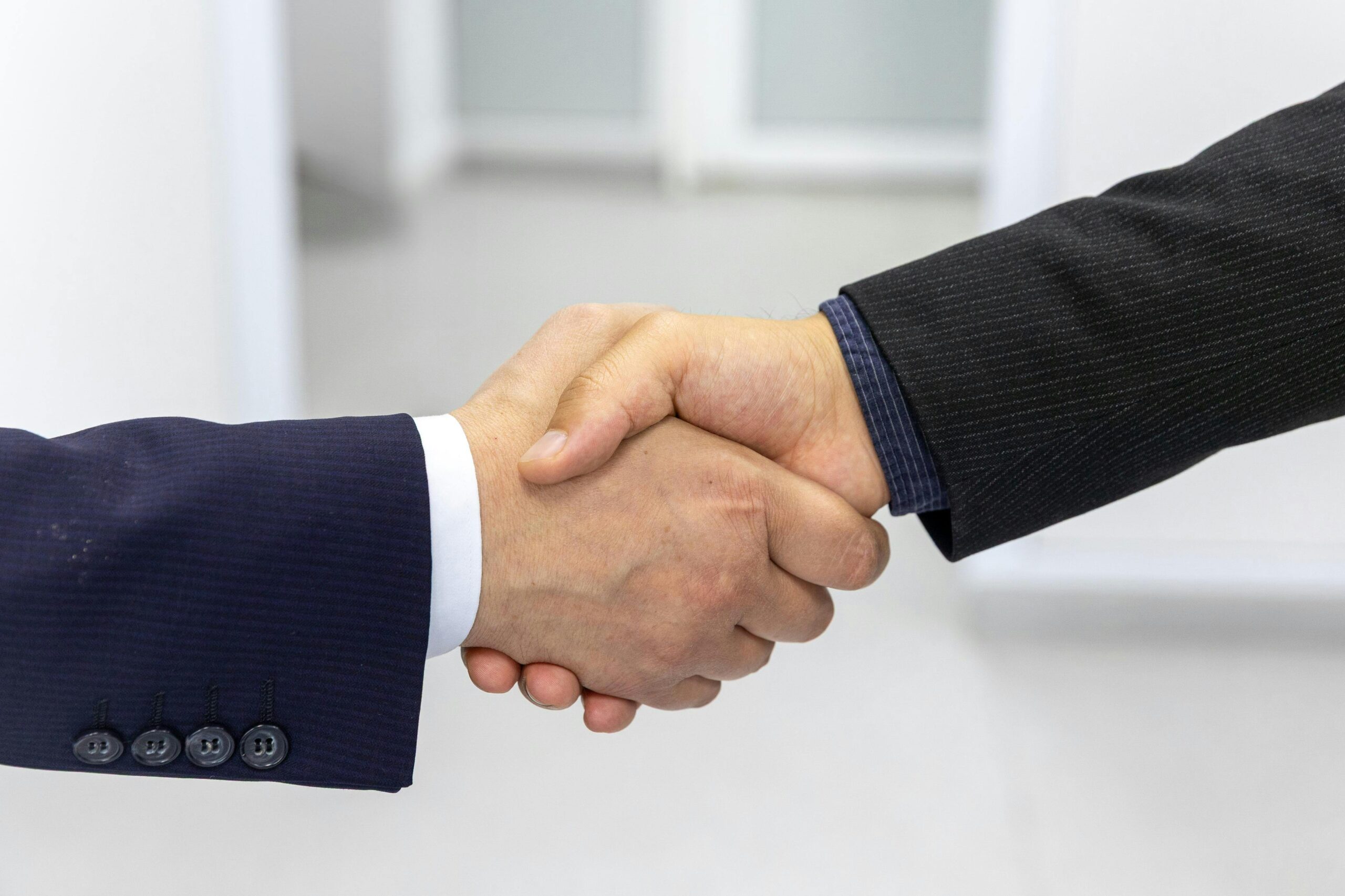 Business handshake representing trust and commitment in a signature coaching program