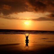 Person practicing meditation at sunrise on a beach, symbolizing inner peace and personal growth—an ideal representation of the journey through mindfulness certification.