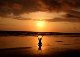 Person practicing meditation at sunrise on a beach, symbolizing inner peace and personal growth—an ideal representation of the journey through mindfulness certification.